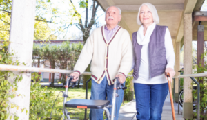 Couple with walking frame and walking stick