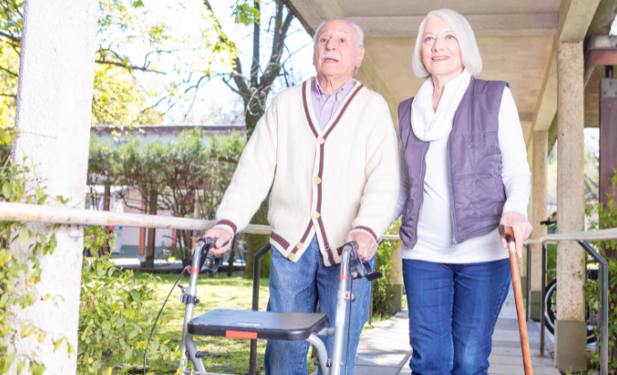 Couple with walking frame and walking stick
