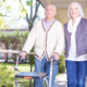 Couple with walking frame and walking stick