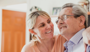 Elderly man photographed smiling with loved one.