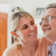 Elderly man photographed smiling with loved one.