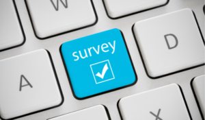 Blue survey icon on keyboard for the communications survey article.