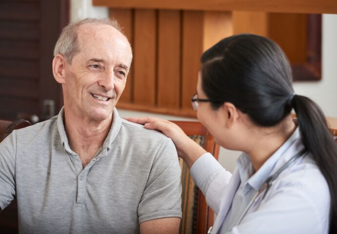 Older man with lady hand on shoulder