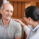Older man with lady hand on shoulder