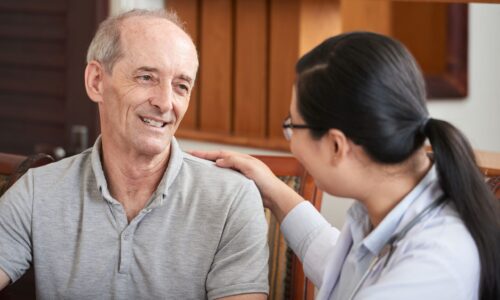 Older man with lady hand on shoulder