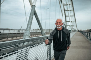 Older man walking on bridge