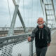 Older man walking on bridge