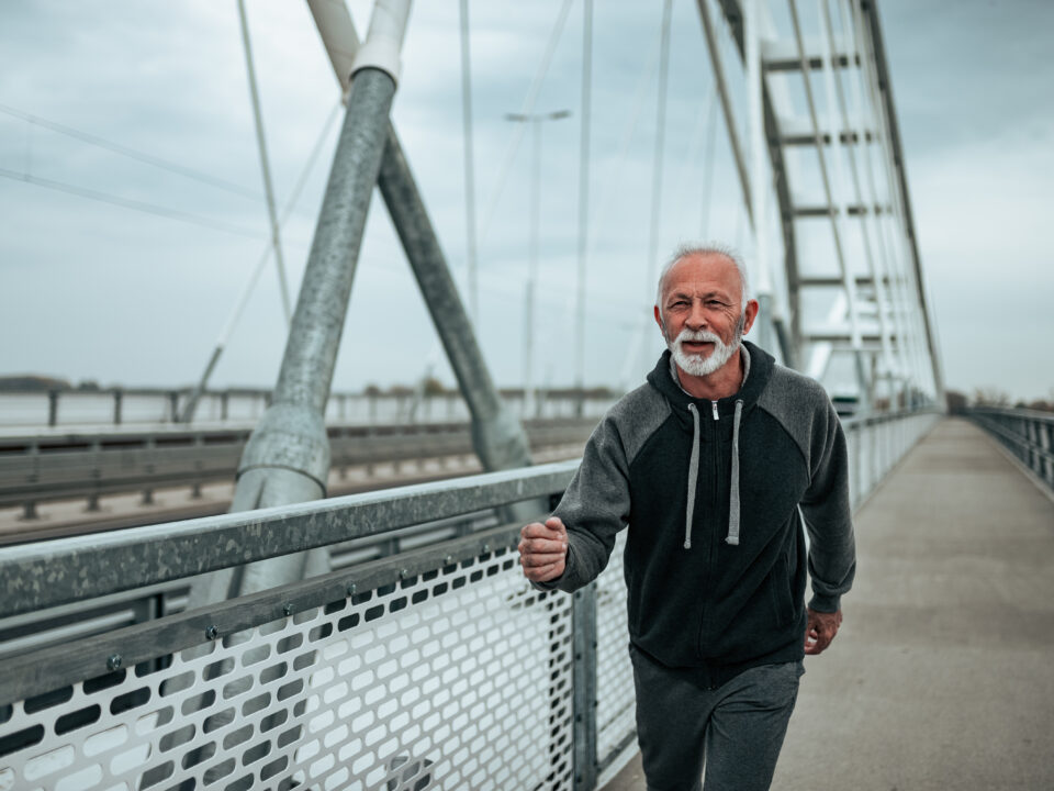 Older man walking on bridge