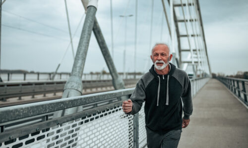 Older man walking on bridge